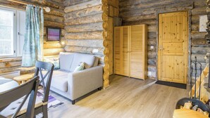 Ein Blockhaus-Interieur mit einer Couch, Holztüren und einem Kamin.