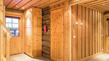 A wooden interior with a stone wall, wooden doors, and a window.