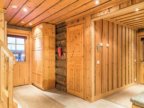 A wooden interior with a stone wall, wooden doors, and a window. - Operonmukka a 8 by Interhome (Kittilä)