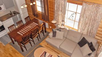 Un interior de cabaña acogedor con comedor, sofá y cocina.