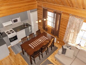 A compact kitchen with a dining area, a sofa, and a window with curtains. - Mervinrinne by Interhome (Sodankylä)