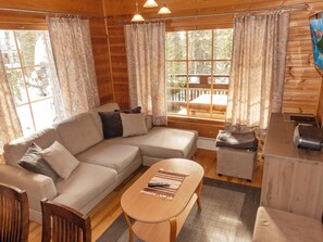A cozy cabin interior with a sectional sofa, a small table, and a television on a wooden stand. - Mervinrinne by Interhome (Sodankylä)