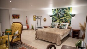 A bedroom with a bed, a chair, a table, and a rug. - Mas de Bellegou B&B (Portiragnes)