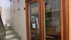 A staircase leading to a room with a wooden bookcase filled with books. - Mas de Bellegou B&B (Portiragnes)