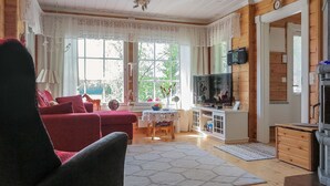 Una sala de estar acogedora con un sofá rojo, un televisor y una chimenea.
