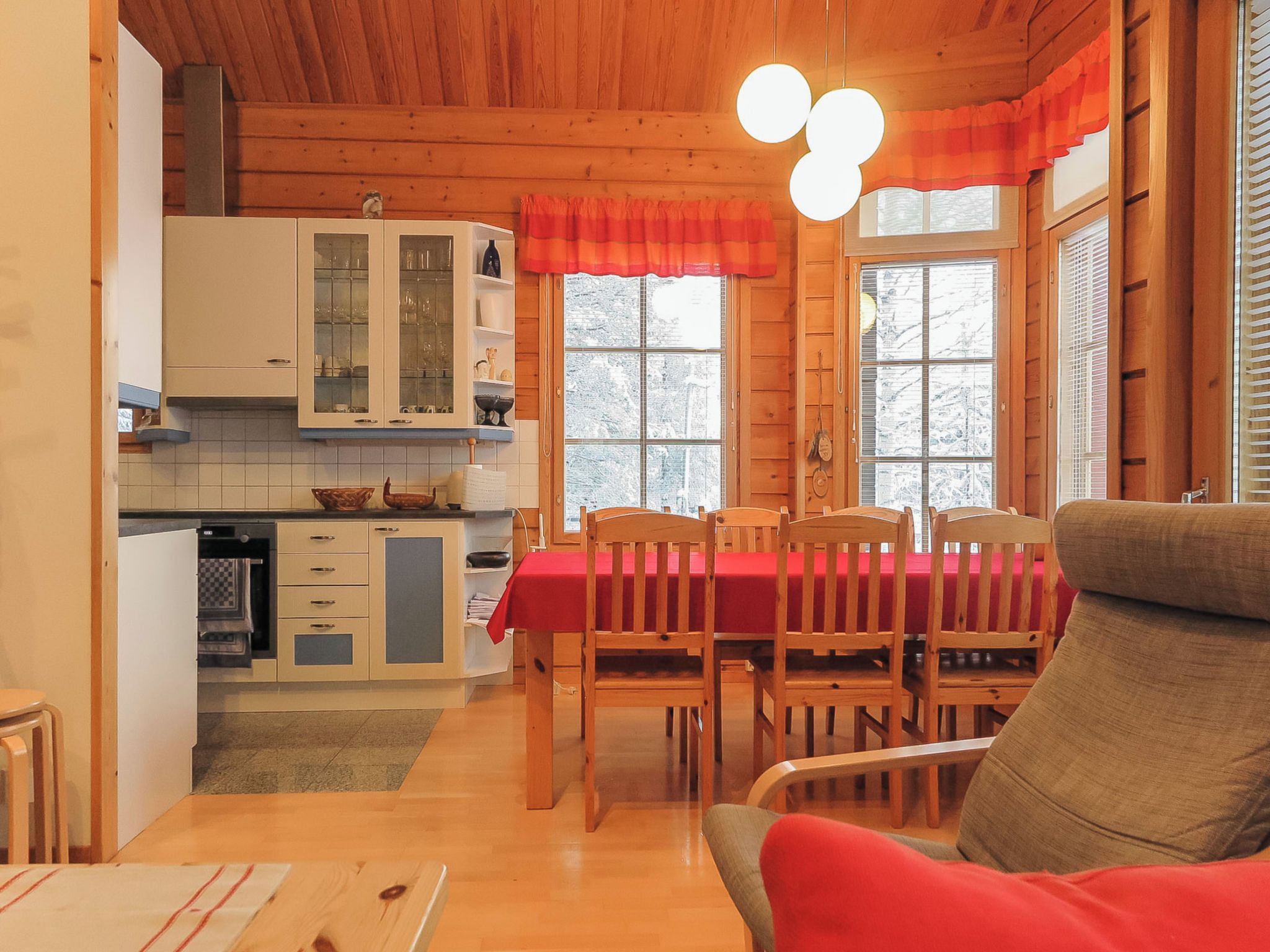 Un interior de madera con comedor, cocina y una zona de estar acogedora.