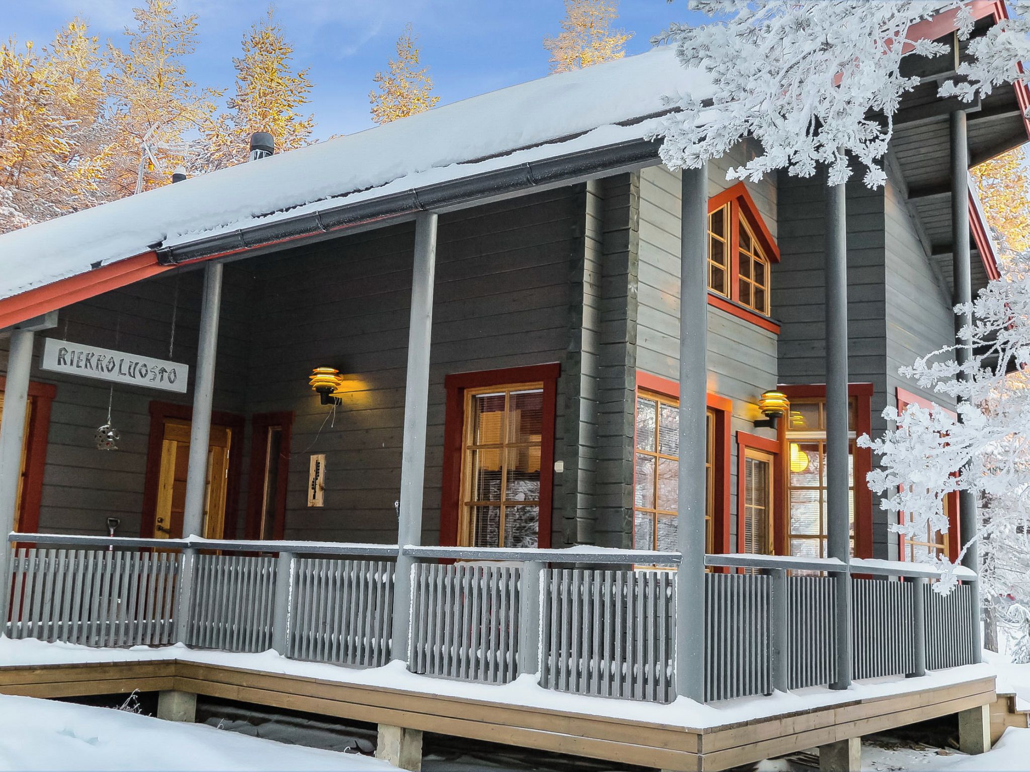 A wooden building with a covered porch and a sign that reads 'RIEKKOLUOSTO'.