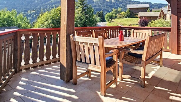 A wooden deck with a table and chairs, overlooking a mountainous landscape. - Chalet Le Renard Du Lac- close to the Chavanne piste and lake (Les Gets)