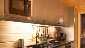 Une cuisine moderne avec des meubles en bois, un évier en acier inoxydable et un four à micro-ondes.