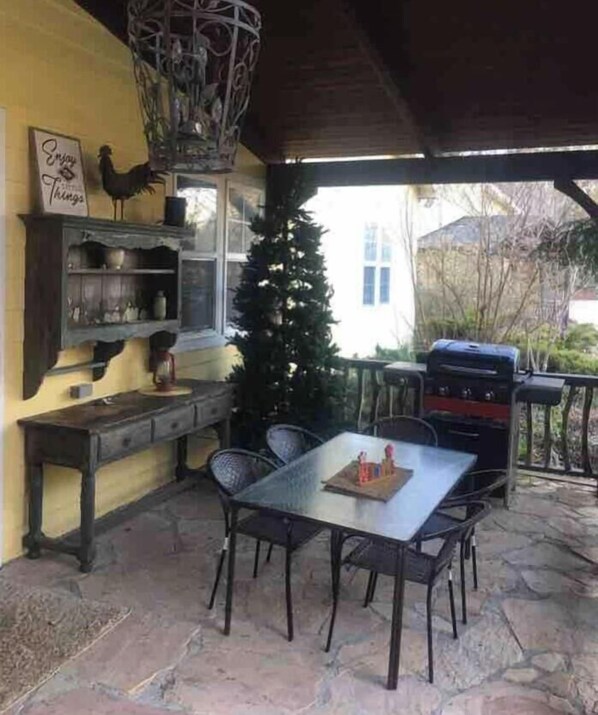 A covered patio with a stone floor, a table with chairs, a grill, and a Christmas tree. - " Casa Grande" Hot Tub_ Indoor Basketball + Movie (Brevard)