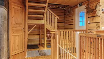 Un intérieur en bois avec un escalier, une porte et une fenêtre.