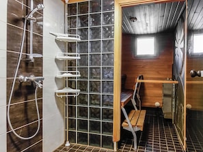 A shower area with a glass partition, a bench, and a window. - Ylikyrön mökki by Interhome (Enontekiö)