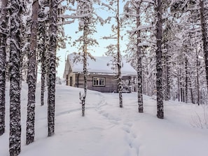 A snow-covered cabin surrounded by trees. - Ylikyrön mökki by Interhome (Enontekiö)