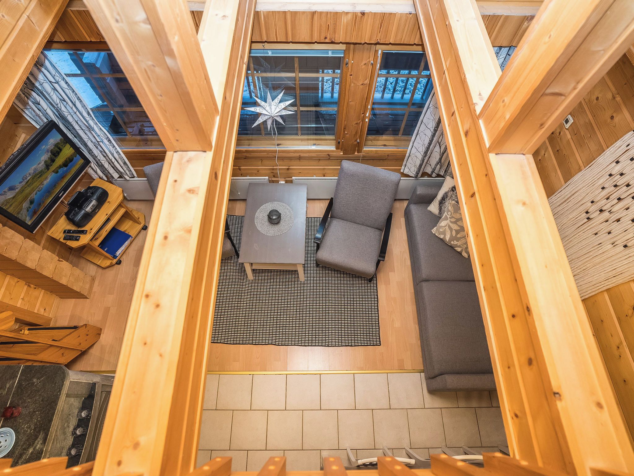 Un interior acogedor con techo de madera, un sofá, una mesita y una decoración con motivos de estrellas.