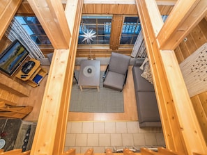 A cozy interior with a wooden ceiling, a sofa, a small table, and a star decoration.
