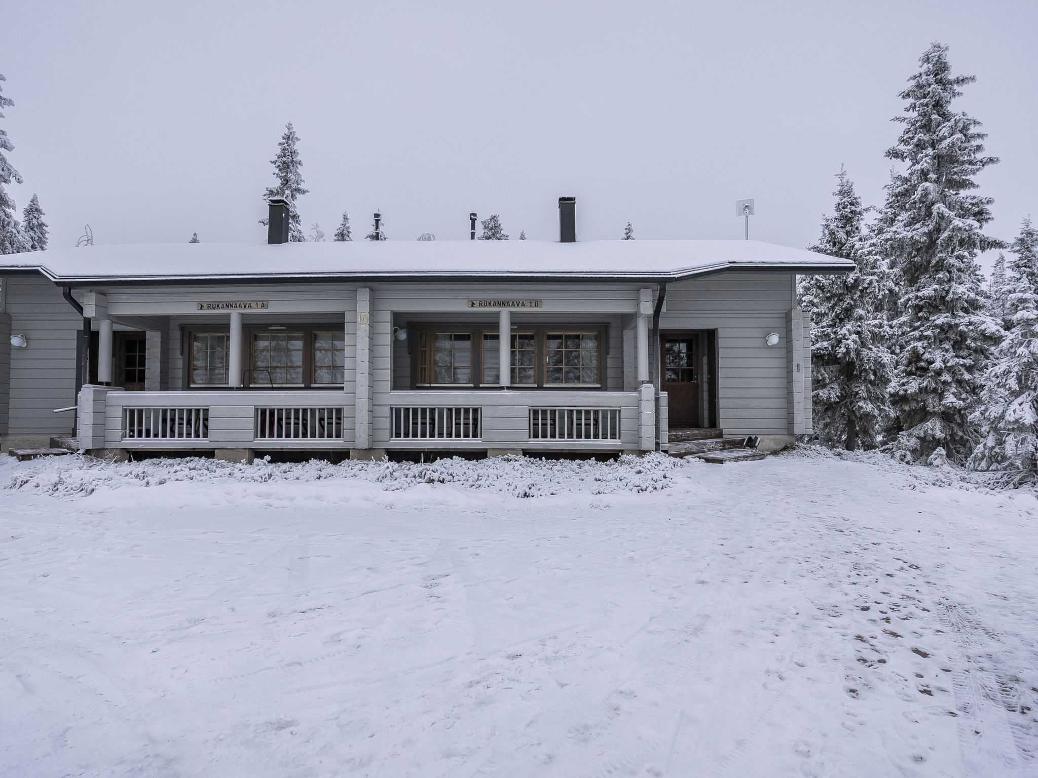 A two-story building with a porch and a covered entrance.
