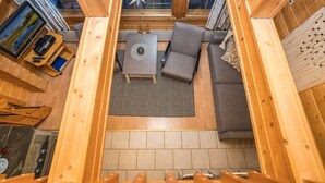 A cozy wooden interior with a sofa, a small table, and a star decoration on the ceiling.