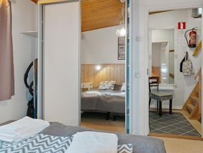Cozy retreat with a neatly made bed, bedside table, and comfortable chair.