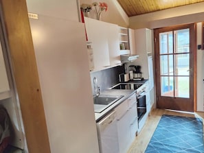Compact kitchen with stainless steel sink, oven, and large window.