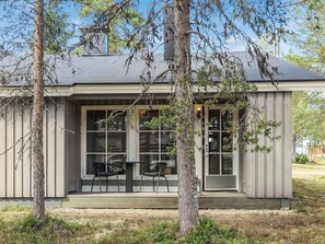 A house with a porch, two chairs, and a window.