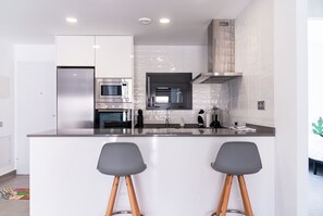 A modern kitchen with a central island, stainless steel appliances, and a minimalist design.