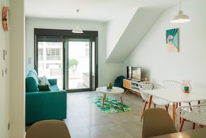 A modern living room with a sofa, a dining table, and chairs.