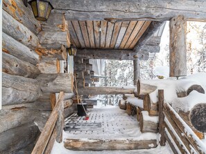 Ein rustikales Blockhaus-Interieur mit schneebedecktem Holzboden und einer einfachen Holzbalkendecke.