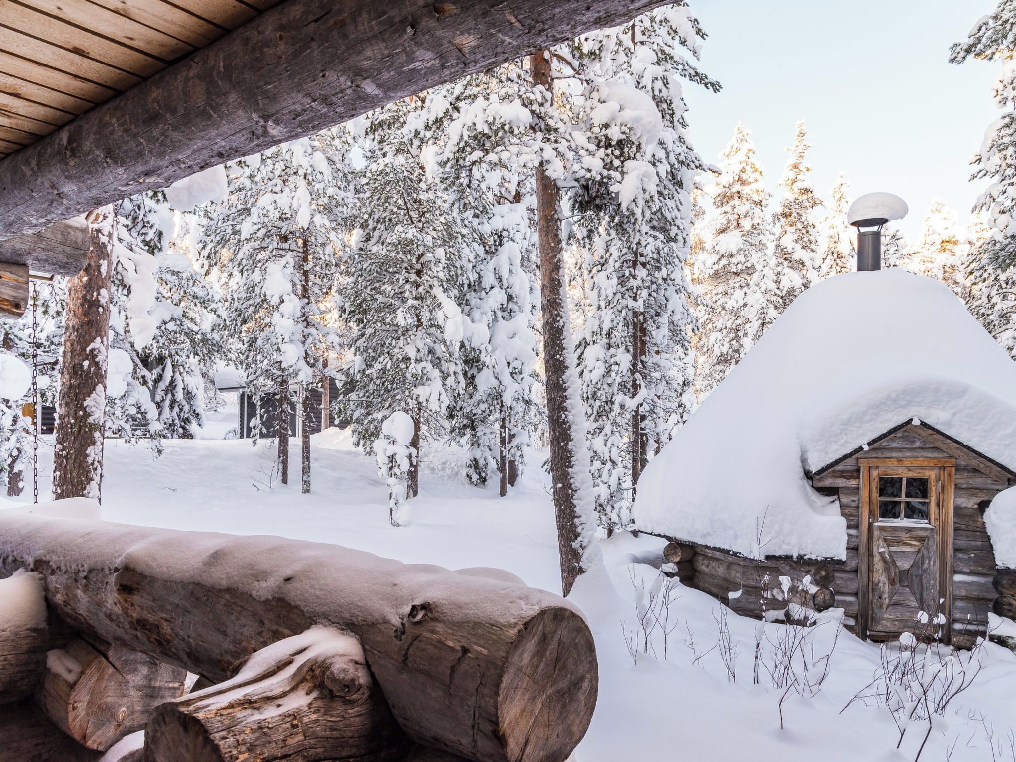 A log cabin surrounded by snow-covered trees.