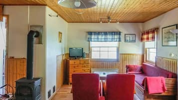 Una habitación acogedora con chimenea, televisión, sofá y una mesa de comedor.