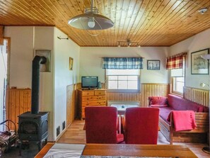 A cozy room with a fireplace, a television, a sofa, and a dining table. - Rantasipi 1 by Interhome (Parainen)