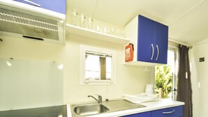 A kitchen with blue cabinets, a stainless steel sink, and a window above the sink. - Vacation home Palma by Interhome (Novigrad (Zadar))