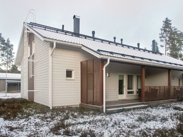 A single-story building with a sloped roof, a covered porch, and a chimney.