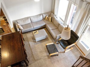 Una sala moderna con un sofá seccional, una mesa de comedor y una silla de cuero negra.
