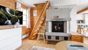 Un intérieur moderne avec une cheminée, un escalier en bois et un coin repas.