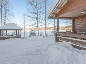 A snow-covered outdoor area with a wooden deck and a gazebo. - Iltarusko by Interhome (Savonlinna)