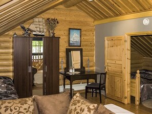 Ein Blockhaushaus-Interieur mit Essbereich, einem großen Holzschrank und einer gemütlichen Sitzecke.
