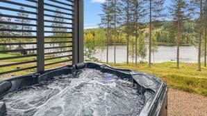 Un jacuzzi con vistas a un lago y árboles.
