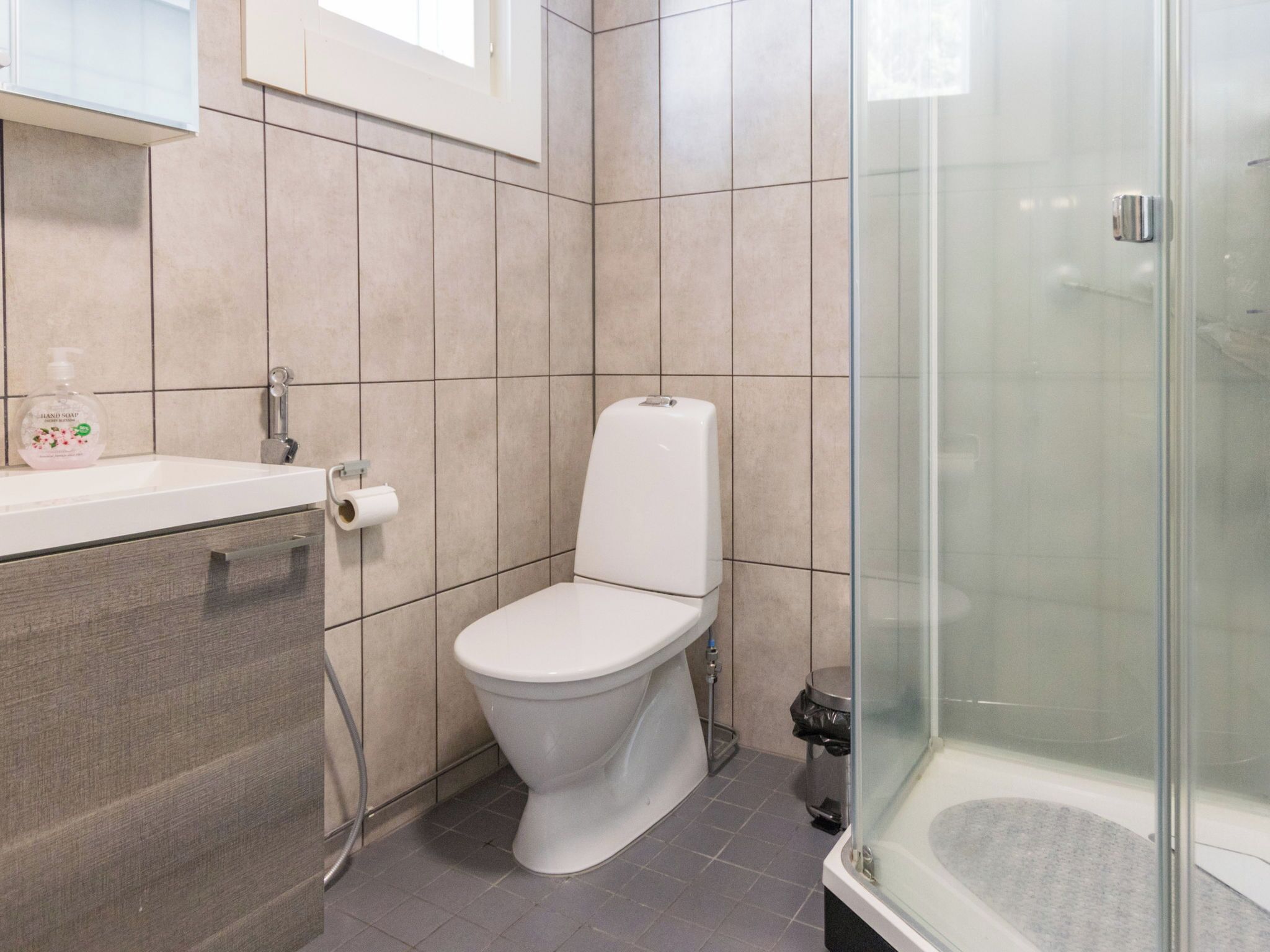 Une salle de bain moderne équipée de toilettes, d’un lavabo et d’une douche à parois en verre.