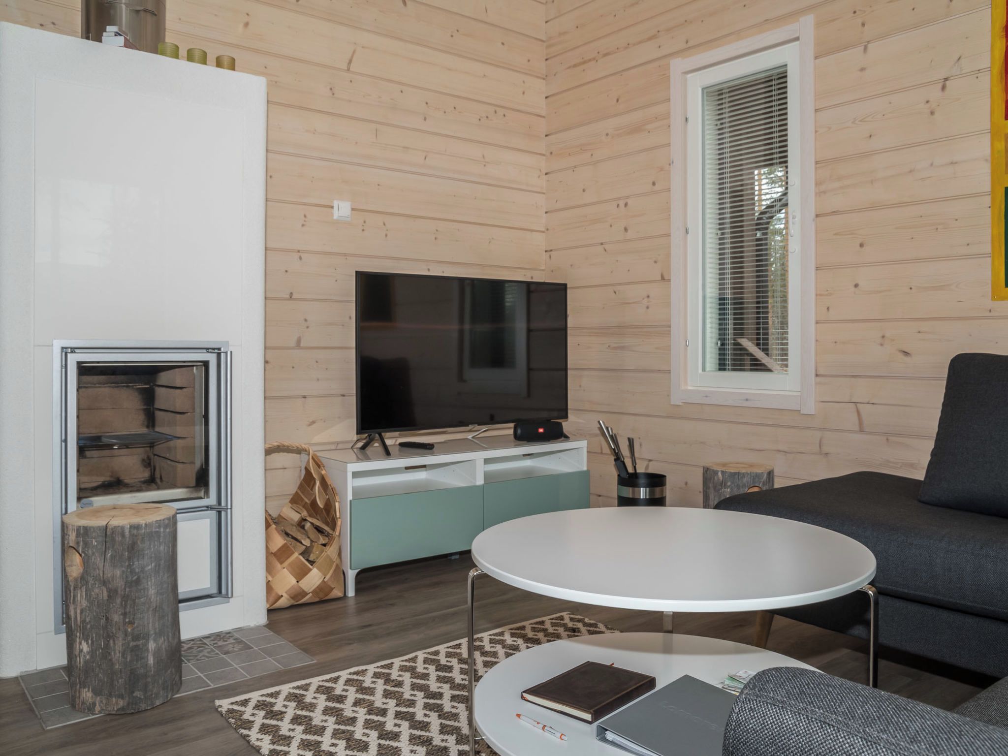 Ein modernes Wohnzimmer mit Flachbildfernseher, einer Couch, einem Couchtisch und einem Kamin.