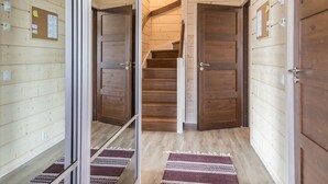 Een houten interieur met een centrale trap, schuifdeuren van glas en een kamerbreed tapijt.