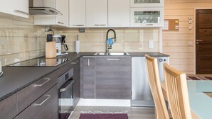 Een moderne keuken met witte kastjes, een roestvrijstalen spoelbak en een inbouw vaatwasser.