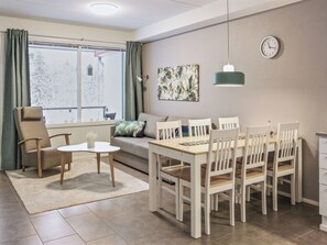 Un salon moderne comprenant un coin repas, un canapé, une table basse et une table à manger avec des chaises.