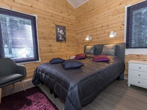 A cozy bedroom with a bed, a chair, a dresser, and a painting on the wall. - Klippan by Interhome (Ruovesi)