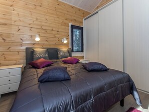 A bedroom with a bed, pillows, a nightstand, a window, and a wardrobe. - Klippan by Interhome (Ruovesi)