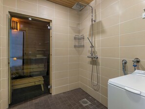 Une salle de bain avec une douche, des toilettes et un banc.