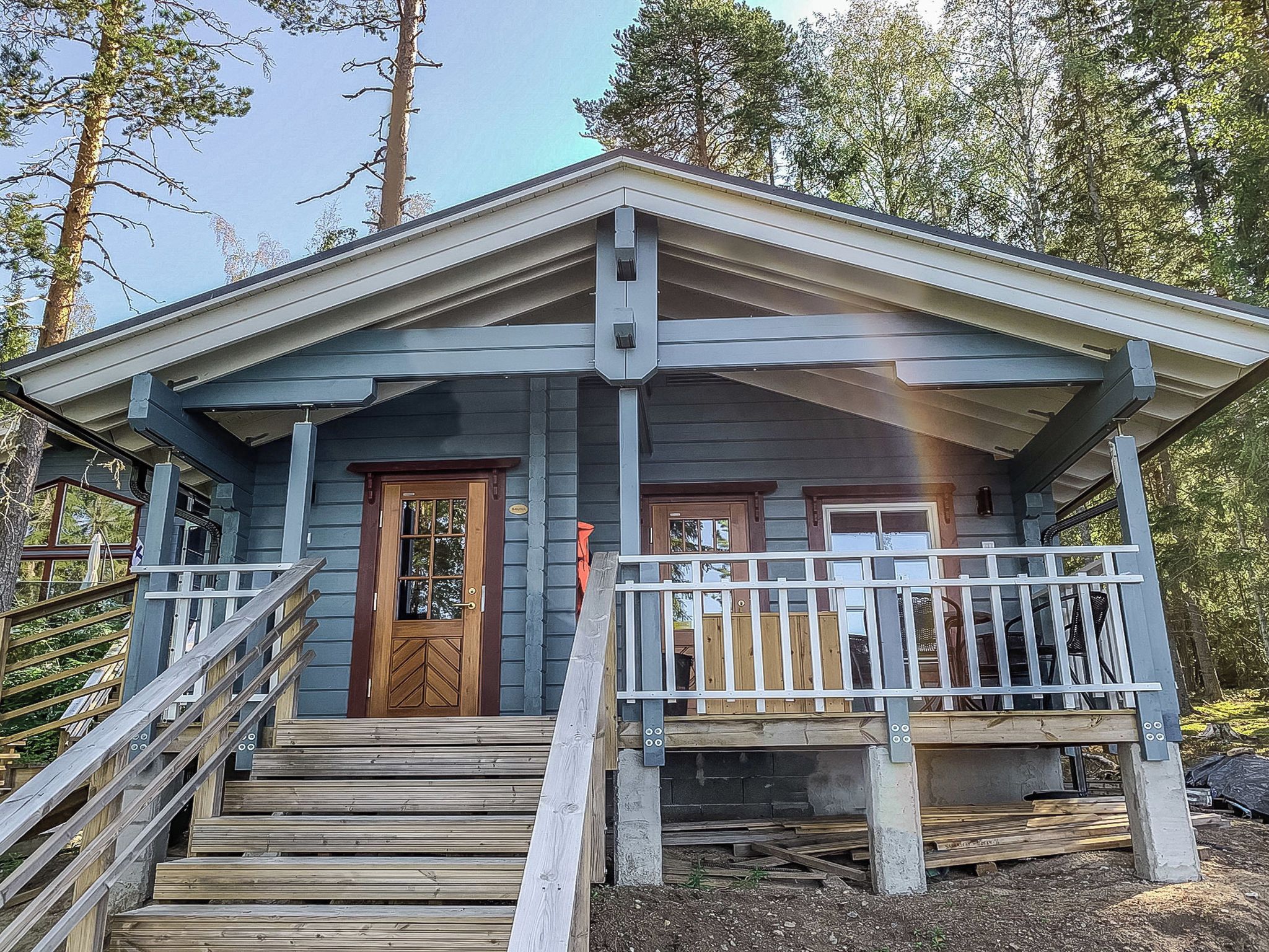 Eine Holzhütte mit einer Veranda und einer Treppe zum Eingang.