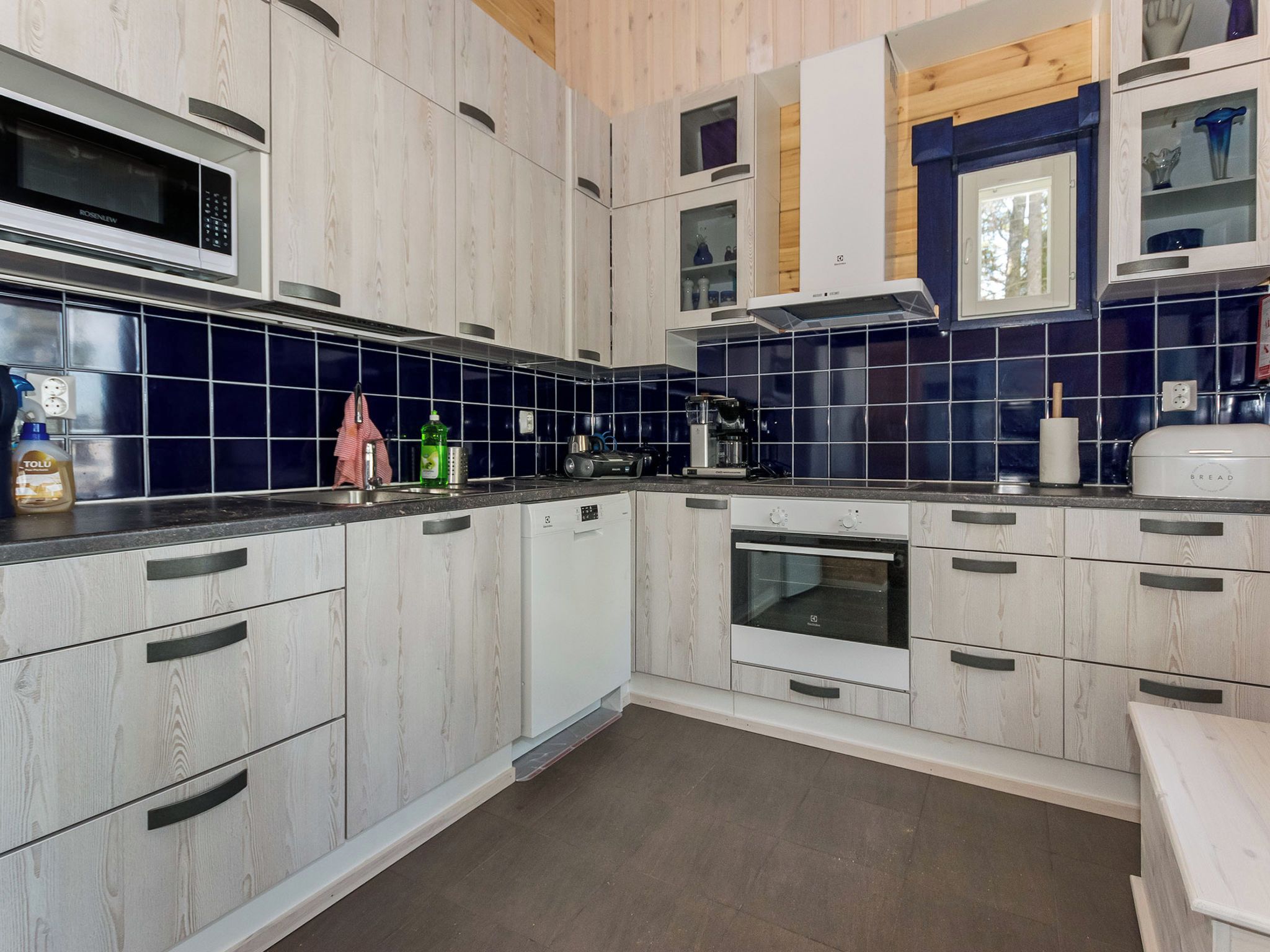 Una cucina moderna con pensili in legno, forno integrato e microonde.