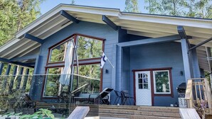 A modern house with a large porch, a covered patio, and a garage.