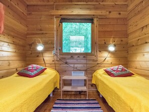 A cabin with two beds, a window, and a small table.