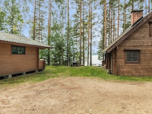 A rustic wooden cabin with a dirt ground and a small grassy area in front. - Auringonlasku by Interhome (Punkaharju)